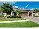 Beautiful home with a three-car garage, well-maintained landscaping and a brick driveway at 13730 Vancanza, Venice, FL 34293