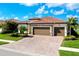 Beautiful home with a three-car garage and well-maintained landscaping and brick driveway at 13730 Vancanza, Venice, FL 34293