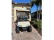 Tan golf cart parked in front of a garage with well-maintained landscaping at 13730 Vancanza, Venice, FL 34293