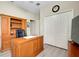This home office has a wooden desk with built-in storage and gray wood flooring at 13730 Vancanza, Venice, FL 34293
