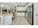 Open kitchen featuring stainless steel appliances, granite counters, and stylish tiled flooring at 13730 Vancanza, Venice, FL 34293