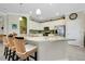 Bright kitchen boasts white cabinets, a large island with bar seating, and stainless steel appliances at 13730 Vancanza, Venice, FL 34293