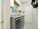 This laundry room is equipped with modern gray appliances and ample storage space at 13730 Vancanza, Venice, FL 34293