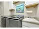 Modern laundry room with gray appliances, a white sink, and ample storage at 13730 Vancanza, Venice, FL 34293
