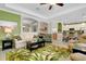 Spacious living room with palm rug, white couch, and view into bright kitchen at 13730 Vancanza, Venice, FL 34293