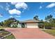 Charming home featuring a well manicured lawn with a two car garage, blue paint, and tile roof at 1700 Manasota Beach Rd, Englewood, FL 34223