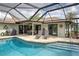 Inviting screened-in pool with brick-paved deck, lounge chairs, and outdoor dining area for relaxation at 1700 Manasota Beach Rd, Englewood, FL 34223