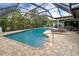 Screened-in pool area with brick-paved deck, lounge chairs, and tropical landscaping for a resort-like feel at 1700 Manasota Beach Rd, Englewood, FL 34223