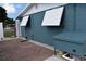 Exterior side of home features a brick area and blue siding at 174 Venice East Blvd, Venice, FL 34293