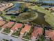 Aerial view of a home with a red tile roof near a lake and golf course at 190 Montelluna Dr # North, North Venice, FL 34275