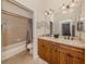 Bathroom featuring a double vanity, tiled shower, and neutral finishes at 190 Montelluna Dr # North, North Venice, FL 34275