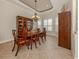 Elegant dining room with a classic chandelier, wood furniture, and natural light from shuttered windows at 190 Montelluna Dr # North, North Venice, FL 34275