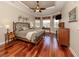 Serene main bedroom with hardwood floors, large windows, and a tray ceiling with a ceiling fan at 190 Montelluna Dr # North, North Venice, FL 34275