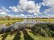 Beautiful view of pond and landscaping, highlighted by blue skies at 190 Montelluna Dr # North, North Venice, FL 34275
