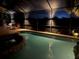 Inviting screened pool with hot tub illuminated at night and outdoor seating area at 190 Montelluna Dr # North, North Venice, FL 34275