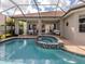Screened-in pool and spa connect to covered patio with seating and dining area at 190 Montelluna Dr # North, North Venice, FL 34275