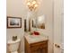 Charming powder room featuring a decorative mirror, a marble countertop, and classic fixtures at 190 Montelluna Dr # North, North Venice, FL 34275