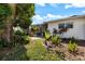 Lush landscaped backyard with a path leading to a screened-in porch and seating area at 225 Randolph Rd, Venice, FL 34293