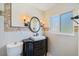 Chic bathroom with custom vanity, decorative mirror and sconces, and stylish wall tiles at 225 Randolph Rd, Venice, FL 34293