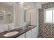 Modern bathroom featuring double sinks, granite counters, decorative tile and a glass-enclosed shower at 225 Randolph Rd, Venice, FL 34293