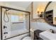 Bathroom featuring tiled shower, custom vanity, sconces, and large framed mirror at 225 Randolph Rd, Venice, FL 34293