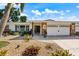 Charming single-Gathering home with a manicured lawn, stone accents, and a well-lit driveway leading to a two-car garage at 225 Randolph Rd, Venice, FL 34293