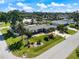 Landscaped front yard with tropical plants, lush green grass and mature trees under a sunny blue sky at 225 Randolph Rd, Venice, FL 34293