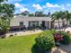 Beautifully landscaped front yard with lush green lawn, tropical foliage, and a well-maintained single-story home at 225 Randolph Rd, Venice, FL 34293