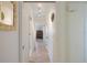 Well-lit hallway with neutral walls, tiled floor, multiple doors and decorative mirror at 225 Randolph Rd, Venice, FL 34293