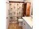 Bathroom features a shower with palm tree curtain, vanity with white cabinets, and unique open shelving at 2863 Twinkle Ave, North Port, FL 34286