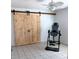 Bedroom with white ceiling fan and tile floors, including an inversion table and barn doors at 2863 Twinkle Ave, North Port, FL 34286