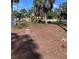 Expansive yard with a lush lawn, mature palm trees, and a charming white picket fence, perfect for outdoor enjoyment at 2863 Twinkle Ave, North Port, FL 34286