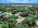 An aerial view of a home in a green neighborhood close to a large commercial building and schools at 3348 Trapper Ln, North Port, FL 34286