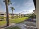 Scenic backyard with a serene lake, palm trees, and lush landscaping at 345 Three Lakes Ln # L, Venice, FL 34285
