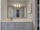 Bathroom boasts a white vanity with drawers, a large mirror, and a storage cabinet on the wall at 345 Three Lakes Ln # L, Venice, FL 34285