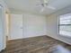 Bright bedroom with wood-look floors, a ceiling fan, and a closet at 345 Three Lakes Ln # L, Venice, FL 34285