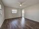Spacious bedroom with dark wood-look floors, fan, and access to outdoor balcony at 345 Three Lakes Ln # L, Venice, FL 34285