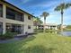Exterior view of the rear of the property, highlighting the private patio area and serene lake views at 345 Three Lakes Ln # L, Venice, FL 34285