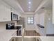 Bright, updated kitchen features stainless steel appliances, white cabinetry, granite countertops, and modern wood-style flooring at 345 Three Lakes Ln # L, Venice, FL 34285