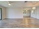 Open living room with wood floors, ceiling fan, sliding glass door and a mirrored wall at 345 Three Lakes Ln # L, Venice, FL 34285