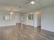 Open-concept living space with wood floors and a pass-through window to the kitchen at 345 Three Lakes Ln # L, Venice, FL 34285