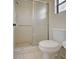 Bright bathroom shower with sliding glass door, grab bar, mosaic floor, and white tile walls at 345 Three Lakes Ln # L, Venice, FL 34285
