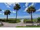 Scenic view of the beach path with benches, leading to ocean, under a bright, sunny sky at 397 Flamingo Dr, Venice, FL 34285