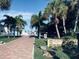 A brick path leads to Golden Beach, surrounded by swaying palm trees and lush greenery at 397 Flamingo Dr, Venice, FL 34285