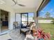 Covered patio featuring brick flooring, ceiling fan, and comfortable wicker furniture at 4054 Coalingo St, North Port, FL 34291