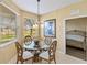 Cozy dining area with a glass table and decorative chandelier near a sunlit window at 4210 Vicenza Dr # A25, Venice, FL 34293