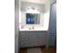 Well-lit bathroom with a single sink vanity, framed mirror, and tiled flooring at 425 Boxwood Dr, Venice, FL 34285