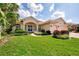 Charming single-story home with well-manicured lawn, vibrant landscaping, and a paver driveway leading to a three-car garage at 4340 Via Del Santi, Venice, FL 34293