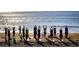 A group practices yoga on the beach as the sun rises over the ocean creating a serene experience at 630 Bird Bay E Dr # 208, Venice, FL 34285