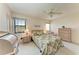 Cozy bedroom with a ceiling fan, a large window and a tropical themed bedspread at 630 Bird Bay E Dr # 208, Venice, FL 34285